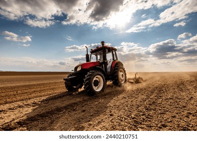 Agriculture machinery in action, a tractor plows a field on a bright day - Powered by Shutterstock