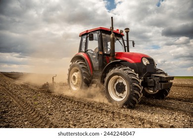 Agriculture machinery in action, a tractor plows a field on a bright day