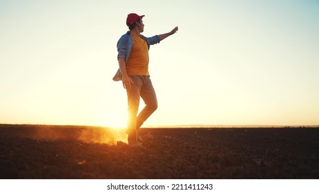 agriculture. a male farmer in rubber boots walks on a plowed agricultural floor. farm worker walking sun home after harvest at the end of the working day legs in rubber boots agriculture - Powered by Shutterstock