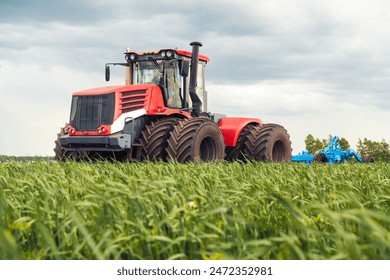 Agriculture. tractor on field of black sail against the background of blue lifestyle clouds. agriculture business industry concept. plow machine tractor farm cultivates the soil after harvest - Powered by Shutterstock