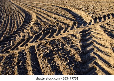 agriculture tractor traces on cultivated farm field soil
