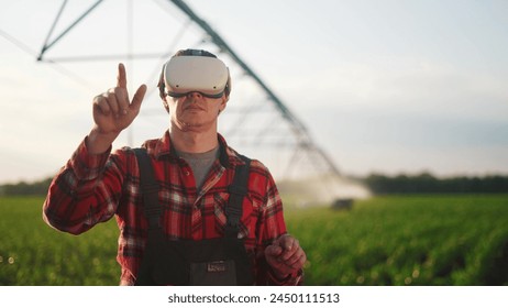 agriculture virtual reality. a farmer in virtual reality glasses controls machine to irrigate corn field. agriculture virtual reality business concept. a farmer vr in works in field with corn - Powered by Shutterstock