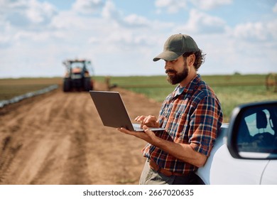 Agronomist using laptop while working in the field. Copy space.