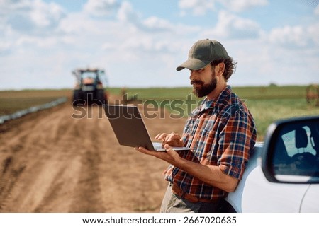 Agronomist using laptop while working in the field. Copy space.