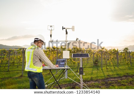 Agronomist using tablet computer collect data with meteorological instrument to measure the wind speed, temperature and humidity and solar cell system in grape agricultural field, Smart farm concept