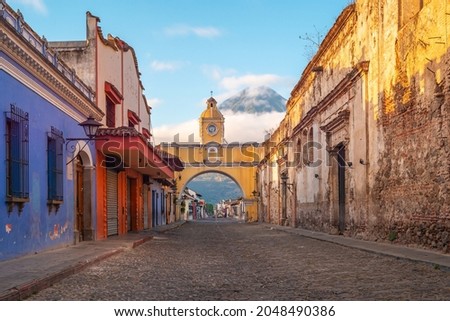 Agua volcano and Santa Catalina arch at sunrise, Antigua city, Guatemala.