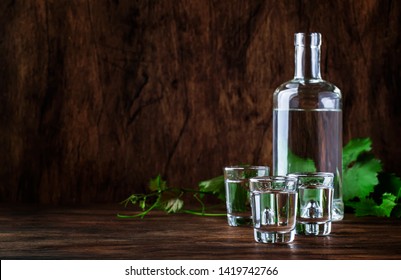 Aguardiente - Traditional Spanish Strong Alcoholic Drink, Grape Moonshine Or Vodka, In Glasses On An Old Wooden Table, Place For Text