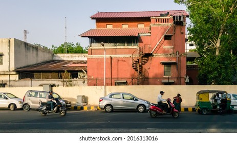 Ahmedabad, Gujarat, India - June 2017: An Old Red Heritage Building With A Spiral Staircase Above A Road In The Old City Area Of Ahmedabad.