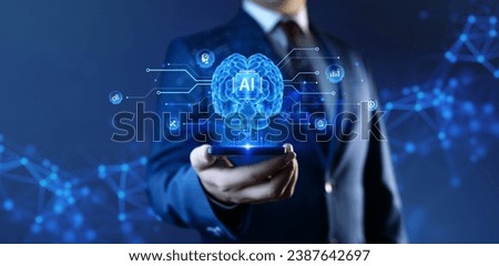 AI - Artificial Intelligence Concept. A businessman holds a smartphone with a hologram of a human brain and HUD of deep machine learning, automation, and Neural Networks