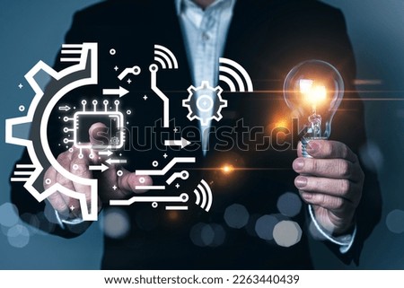 AI (Artificial intelligence) concept, microchip, businessman hold light bulb and touching AI infographic, gear cogs icons, creative idea, AI technology, quantum computing, cloud computing, automation.