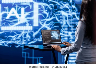 AI computer scientist using laptop for business data analysis in high tech workplace. Close up shot of woman working on notebook to automatize tasks using artificial intelligence