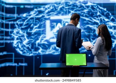 AI developers colleagues using green screen laptop for business data analysis. IT specialists in high tech location work on chroma key notebook to automatize tasks using artificial intelligence