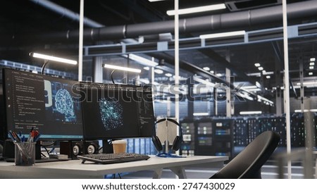 AI development workstation in data center with dual monitors displaying machine learning code. Server hub computers used for tracking neural network structures algorithm performance