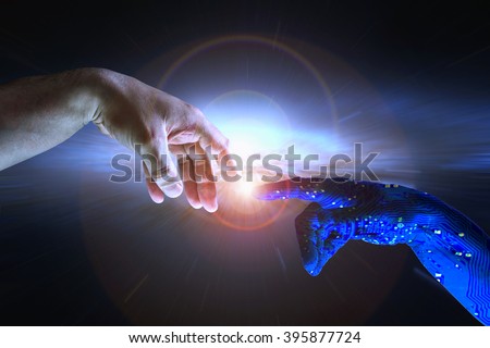 AI hand reaches towards a human hand as a spark of understanding technology reaches across to humanity. Artificial Intelligence concept copy space area. Blue cyborg arm and flare science background