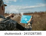 AI technology in the army. Warfare analytic operator checking coordination of the military team. Military commander with a digital tablet device with artificial intelligence operating troops outdoors.