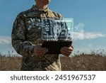 AI technology in the army. Warfare analytic operator checking coordination of the military team. Military commander with a digital tablet device with artificial intelligence operating troops outdoors.