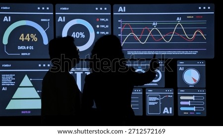 AI Using. Silhouetted analysts interact with a large AI data. AI Display charts graphs and analytics. Business team using futuristic AI interface visuals data. Technology with biz insight and big data