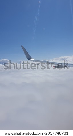 Aicraft wing in air during a flight over London United Kingdon against cloudy sky
