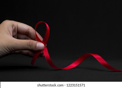 Aids red ribbon on woman's hand support for World aids day and national HIV/AIDS and aging awareness month concept - Powered by Shutterstock