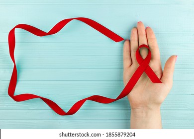 Aids red ribbon on woman's hand support for World aids day and national HIV/AIDS and aging awareness month concept, Anorexia problem, Vasculitis problem - Powered by Shutterstock