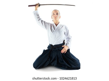 Aikido master practices defense posture. Healthy lifestyle and sports concept. Woman in white kimono on white background. Karate woman with concentrated face in uniform.