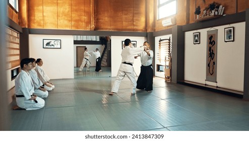 Aikido, sensei y estudiantes japoneses con entrenamiento, aptitud y acción en clase para defensa o técnica. Artes marciales, personas o luchas con disciplina, uniforme o confianza en la cultura y la habilidad