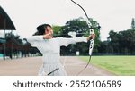 Aim, athlete and woman with bow, field and serious for challenge, training and equipment for sport. Outdoor, skills and talent for archery, shooting and arrow for practice, archer and person in Japan