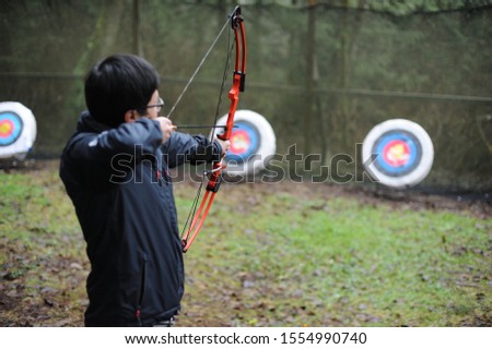 Aiming at the target with bow and arrow