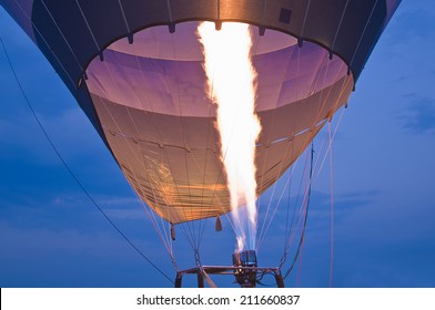 Air balloon starts to fly in the evening sky.