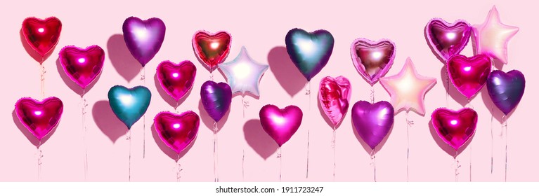 Air Balloons. Bunch of colorful purple, pink, blue heart shaped foil balloons on pink background. Love. Holiday celebration. Valentine's Day party decoration. Birthday. Metallic balloon. Wide screen. - Powered by Shutterstock