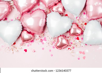 Air Balloons of heart shaped foil  on pastel pink background. Love concept. Holiday celebration. Valentine's Day or wedding/bachelorette party decoration. Metallic balloon