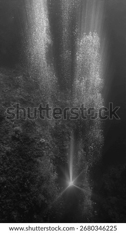 Air bubbles from the deep in rays of light. Scuba dive art and underwater photography. 
