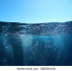 Air bubbles underwater sea and blue sky, split view over and under water surface, Mediterranean sea