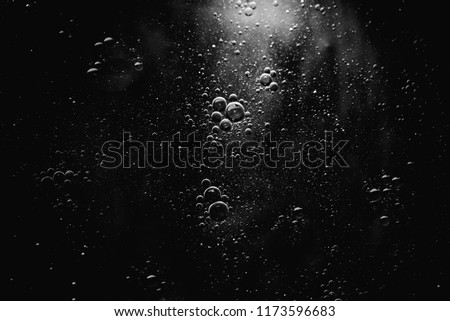Air bubbles in the water background.Abstract oxygen bubbles in the sea.Water bubbles isolate on black background.Black and white tone style.