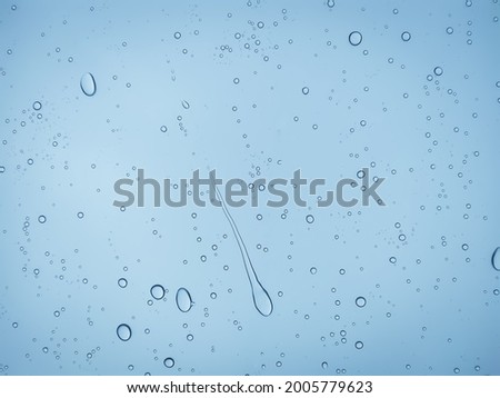 Air bubbles or water droplets or raindrops on glass.Raindrops blue tones