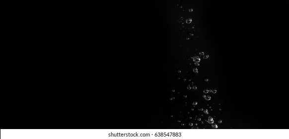 Air Bubbles In Water Isolated In Black Background.