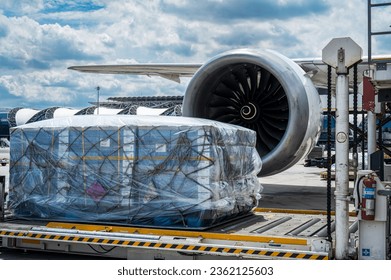 Air cargo logistic containers are loading to an airplane. Air transport shipment prepare for loading to modern freighter jet aircraft at the airport.