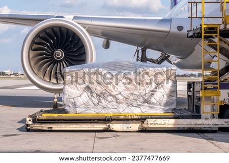 Air cargo logistic containers are loading to an airplane. Air transport shipment prepare for loading to modern freighter jet aircraft at the airport.