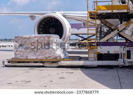 Air cargo logistic containers are loading to an airplane. Air transport shipment prepare for loading to modern freighter jet aircraft at the airport.
