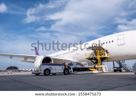 Air cargo logistic containers are loading to an airplane. Air transport shipment prepare for loading to modern freighter jet aircraft at the airport.