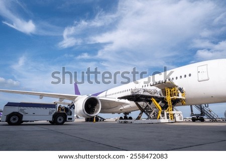 Air cargo logistic containers are loading to an airplane. Air transport shipment prepare for loading to modern freighter jet aircraft at the airport.
