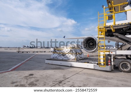 Air cargo logistic containers are loading to an airplane. Air transport shipment prepare for loading to modern freighter jet aircraft at the airport.