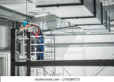 Air Climate Control Theme. Commercial Heating Unit Installation In A Warehouse By Caucasian Heating And Cooling Technician.