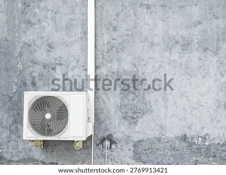 Air compressor cold temperature on wall grey cement building outdoor construction, electric fan power supply technology