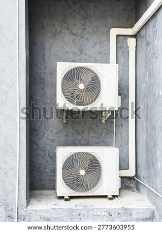 Air compressor cold temperature on wall grey cement building outdoor construction, electric fan power supply technology