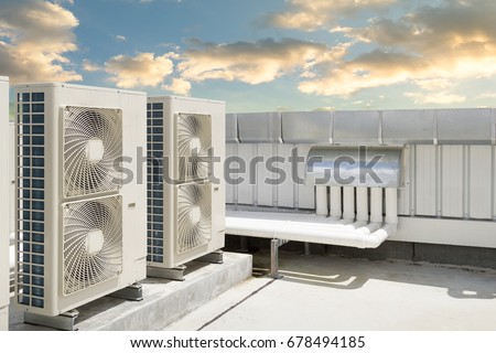 Air compressor or air condenser unit located on roof deck building to heat released transferred to surrounding environment, Compressor is part of cooling function and air conditioning HVAC systems.