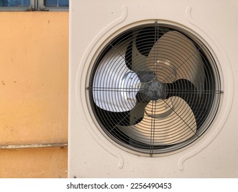 Air compressor or air conditioning unit located on the wall of  building outside to heat released transferred to the surrounding environment.Copy space for text in left side.