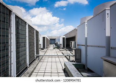 Air compressor machine part of air conditioner system on roof deck with sky background.