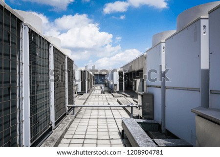Air compressor machine part of air conditioner system on roof deck with sky background.
