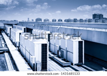 Air compressor machine part of air conditioner system on roof deck with sky background.
